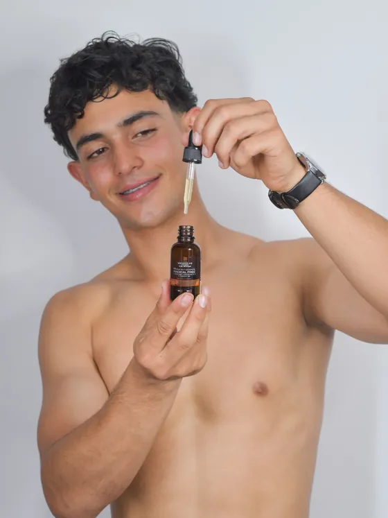 Hombre joven aplicando el Sérum Radical Free con gotero