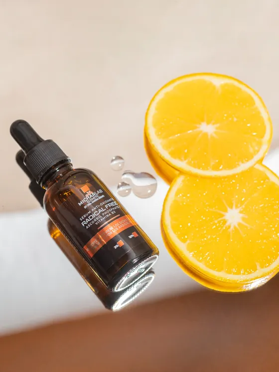 Sérum Radical Free junto a rodajas de naranja